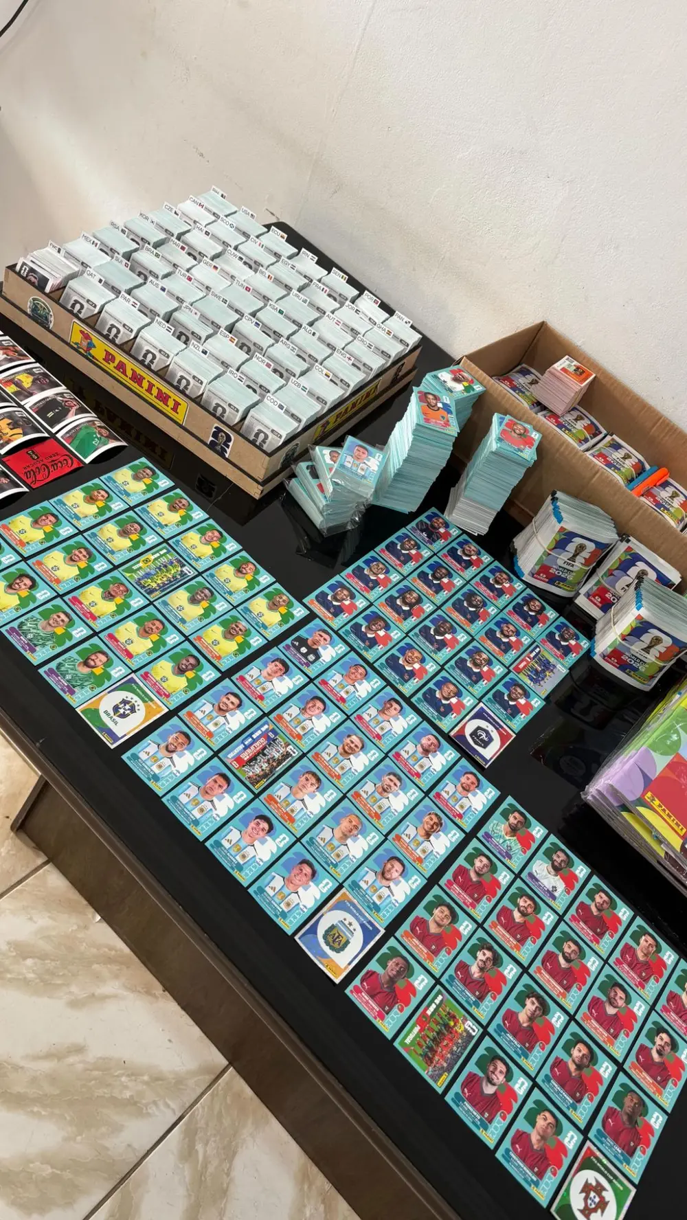Organizador de madeira da Panini com figurinhas separadas por seleção